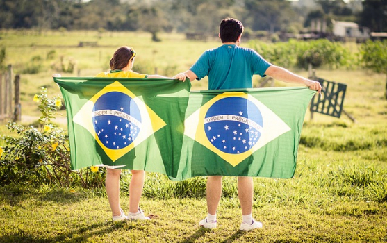 eine Frau und ein Mann, die jeweils eine brasilianische Flagge halten